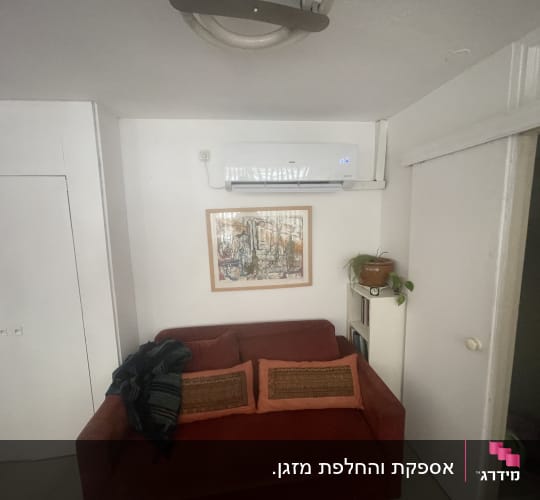 התקנת מזגן עילי לבן על קיר בחדר מגורים